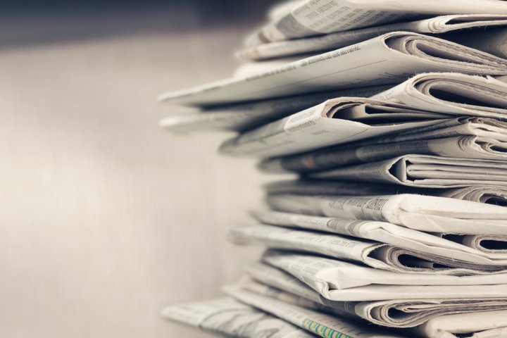 Pile of newspapers on white background Medienkontakt